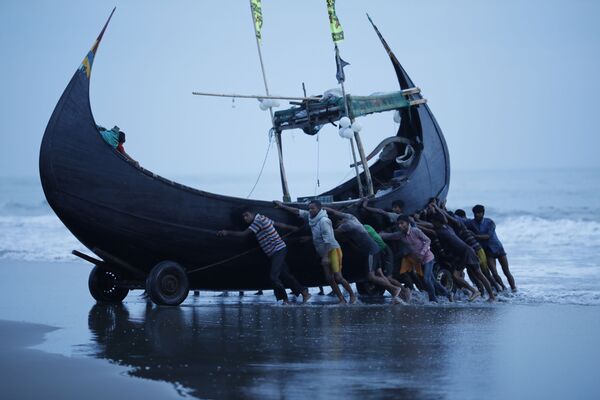 Рыбаки катят лодку в рыбацкую деревню Шарлапур рядом с Текнафом, Бангладеш - Sputnik Абхазия