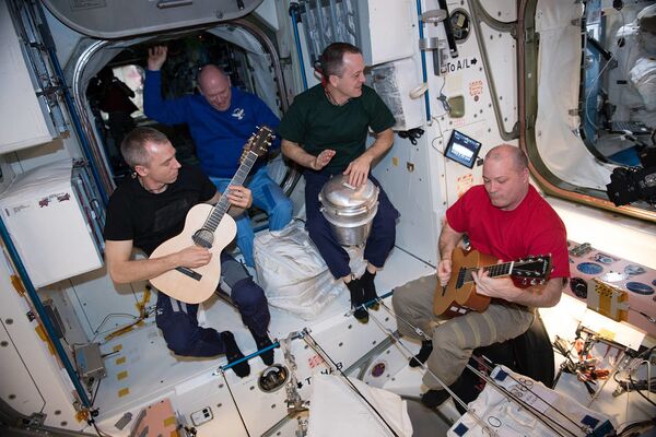 Члены 55 космической экспедиции в время игры на гитаре на борту МКС  - Sputnik Абхазия