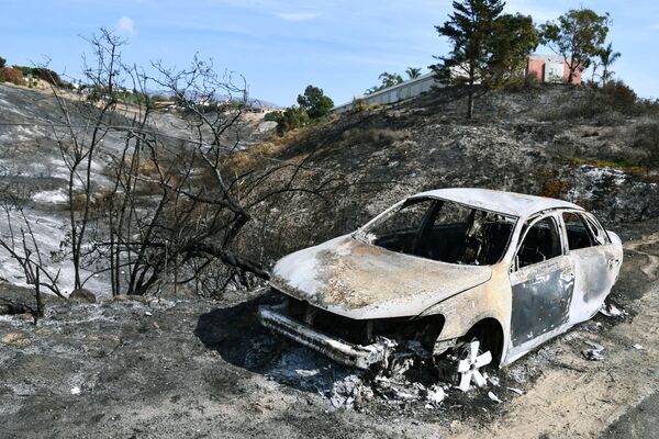 Автомобиль, сгоревший в результате лесных пожаров, в окрестностях города Малибу в штате Калифорния - Sputnik Абхазия