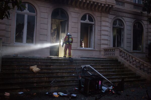 Сотрудник противопожарной службы в доме, пострадавшем от пожара во время протестной акции движения автомобилистов желтые жилеты, в Париже - Sputnik Абхазия
