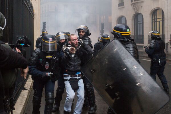 Сотрудники правоохранительных органов и активист во время протестной акции движения автомобилистов желтые жилеты в Париже - Sputnik Абхазия