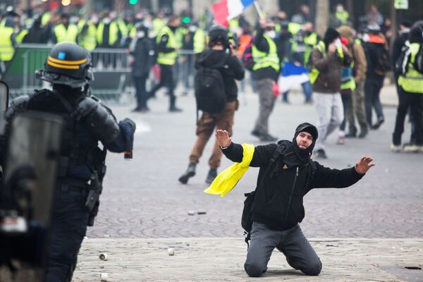 Сотрудник правоохранительных органов и активист во время протестной акции движения автомобилистов желтые жилеты, выступавшего с требованием снижения налогов на топливо, в районе Триумфальной арки в Париже - Sputnik Абхазия