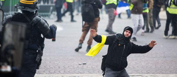 Сотрудник правоохранительных органов и активист во время протестной акции движения автомобилистов желтые жилеты, выступавшего с требованием снижения налогов на топливо, в районе Триумфальной арки в Париже Сотрудник правоохранительных органов и активист во время протестной акции движения автомобилистов желтые жилеты, выступавшего с требованием снижения налогов на топливо, в районе Триумфальной арки в Париже - Sputnik Абхазия