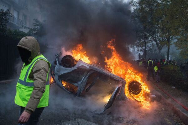 Автомобиль, горящий во время протестной акции движения автомобилистов желтые жилеты, выступавшего с требованием снижения налогов на топливо в Париже - Sputnik Абхазия