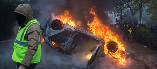 Автомобиль, горящий во время протестной акции движения автомобилистов желтые жилеты, выступавшего с требованием снижения налогов на топливо в Париже Автомобиль, горящий во время протестной акции движения автомобилистов желтые жилеты, выступавшего с требованием снижения налогов на топливо в Париже - Sputnik Аҧсны