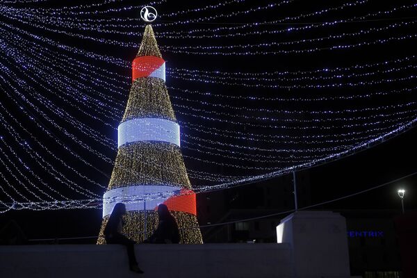 Две девушки у рождественской ели на площади Сальвадора-дель-Мундо в Сан-Сальвадоре, Сальвадор - Sputnik Абхазия