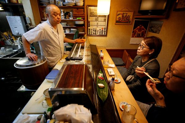 Масатоши Фукуцуна, шеф-повар и владелец суши-бара Эираку в Токио, принимает посетителей - Sputnik Абхазия