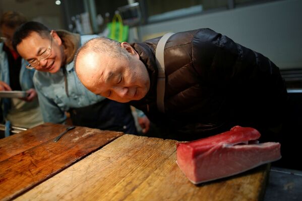 Масатоши Фукуцуна, шеф-повар и владелец суши-бара Эираку в Токио, проверяет качество сырого тунца на рыбном рынке в Токио - Sputnik Абхазия