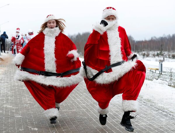 Белорусская пара в костюмах Дедов Морозов принимает участие в новогоднем забеге вокруг озера в Минске, Беларусь - Sputnik Абхазия