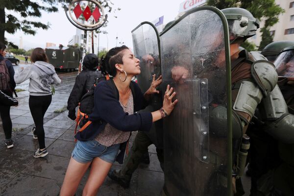 Активистка из племени Мапуче пытается остановить движение сотрудников полиции во время акции протеста в Сантьяго, Чили - Sputnik Абхазия