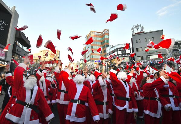 Волонтеры в костюмах Санта Клауса до раздачи подарков бедным семьям в Сеуле  - Sputnik Абхазия