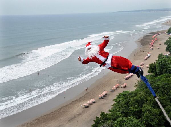 Мужчина в костюме Санта-Клауса во время банджи-джампинга на острове Бали  - Sputnik Абхазия