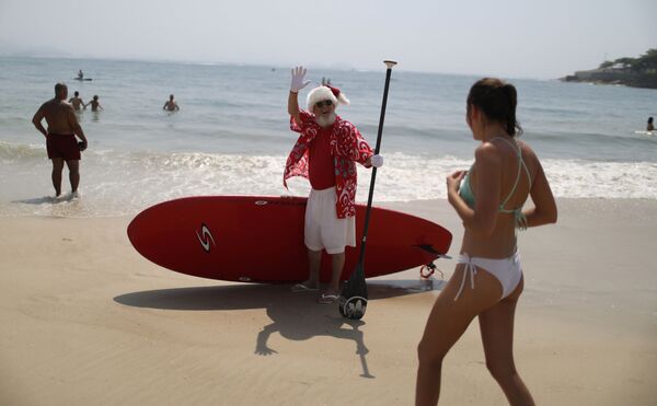 Мужчина в костюме Санта-Клауса на пляже в Бразилии - Sputnik Абхазия