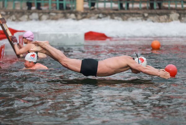 Мужчина во время зимних соревнований по плаванию при температуре минус 21 градуса Цельсия в Шэньяне, провинция Ляонин на северо-востоке Китая - Sputnik Абхазия