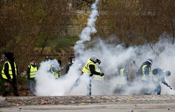 Участники акции протеста желтые жилеты во время столкновения с полицией в Париже - Sputnik Абхазия