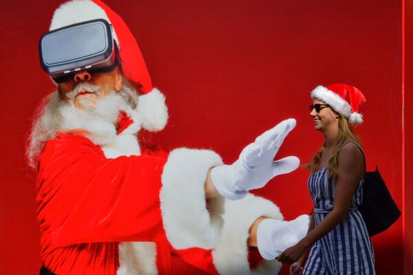 Девушка проходит мимо плаката с изображением Санта-Клауса в Дубае - Sputnik Абхазия