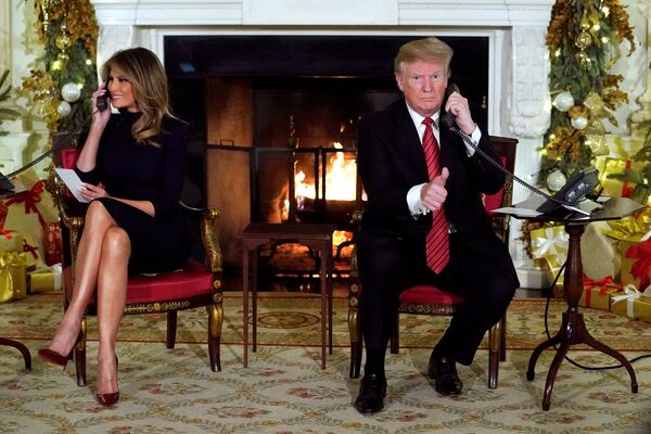 Президент США Дональд Трамп со супругой Меланией во время получения информации о прохождении Санты Клауса в канун Рождества - Sputnik Абхазия