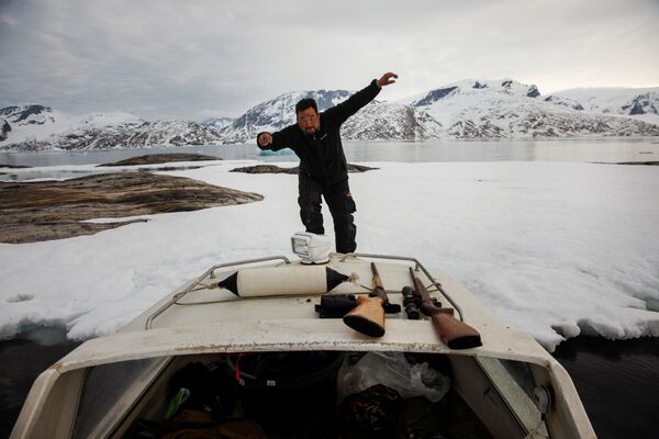 Охотник на тюленей Хенрик Йосвассон запрыгивает обратно на свою лодку после поиска яиц Тупиков возле города Тасиилак, Гренландия - Sputnik Абхазия