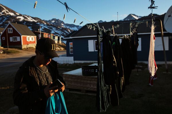 Мужчина вешает белье на веревку в городе Тасиилак, Гренландия - Sputnik Абхазия