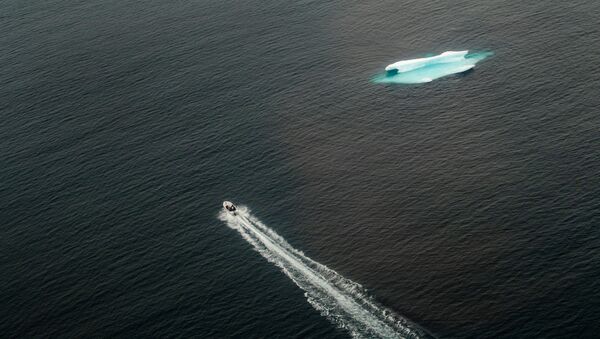 Катер проходит мимо айсберга в открытом океане возле Тасиилака, Гренландия - Sputnik Абхазия