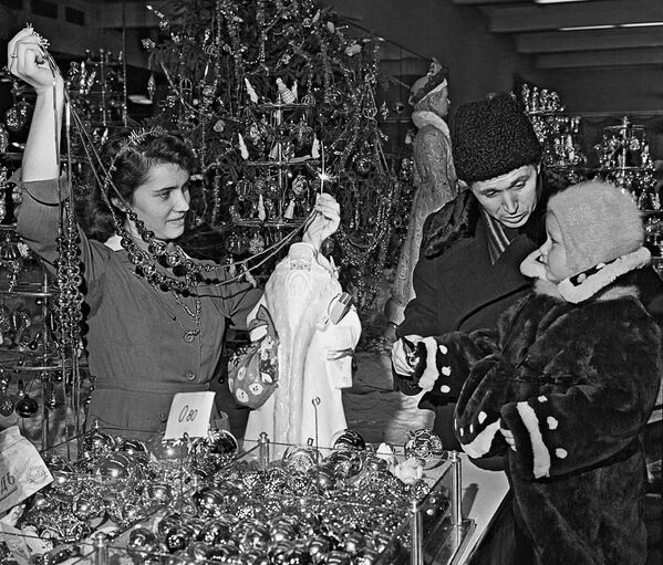 Папа с маленькой дочкой выбирают ёлочные украшения в магазине Детский мир в Москве в 1958 году - Sputnik Абхазия