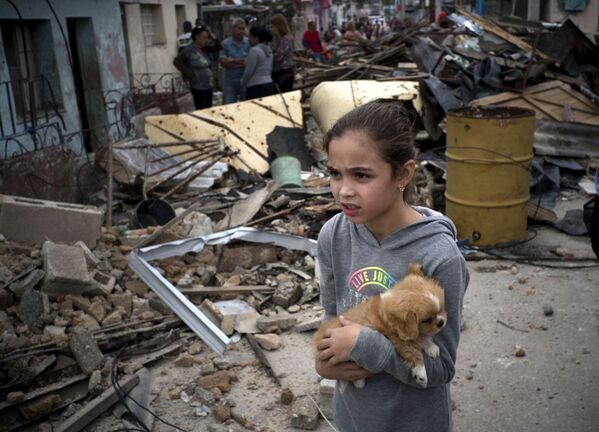  Девочка со щенком среди разрушений в результате прохождения торнадо в Гаване  - Sputnik Абхазия