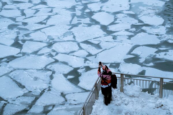 Девушка фотографирует реку Чикаго, после того, как на центральную и восточную часть США обрушился полярный вихрь - Sputnik Абхазия