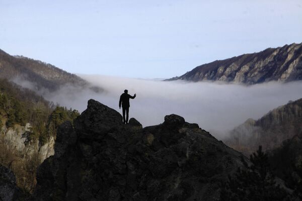 Турист фотографирует туман в ущелье горного склона Галанчожского района Чеченской республики - Sputnik Абхазия