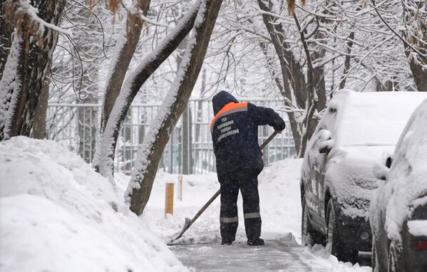 Сотрудник коммунальных служб убирает снег в Москве - Sputnik Абхазия