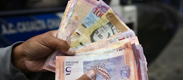 Мужчина пересчитывает деньги на улице в Каракасе - Sputnik Абхазия