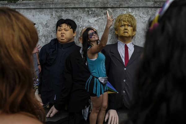 Девушка делает селфи рядом с куклами с президента США Дональда Трампа и северокорейского лидера Ким Чен Ына во время карнавальных торжеств в Олинде, Бразилия - Sputnik Абхазия