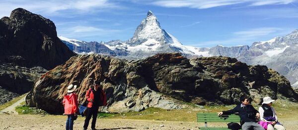 Туристы на фоне горы Маттерхорн в Пеннинских Альпах на границе Швейцарии и Италии Туристы на фоне горы Маттерхорн в Пеннинских Альпах на границе Швейцарии и Италии - Sputnik Абхазия
