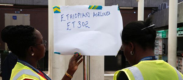 Служащие вывешивают информацию о рейсе ET 302 Эфиопских авиалиний в аэропорту Джомо Кенйятта, Найроби, Кения. 10 марта 2019 - Sputnik Абхазия
