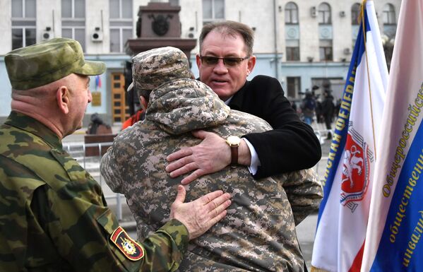 Люди поздравляют друг друга с 5-й годовщиной Общекрымского референдума 2014 года и воссоединения Крыма с Россией на одной из улиц в Симферополе - Sputnik Абхазия