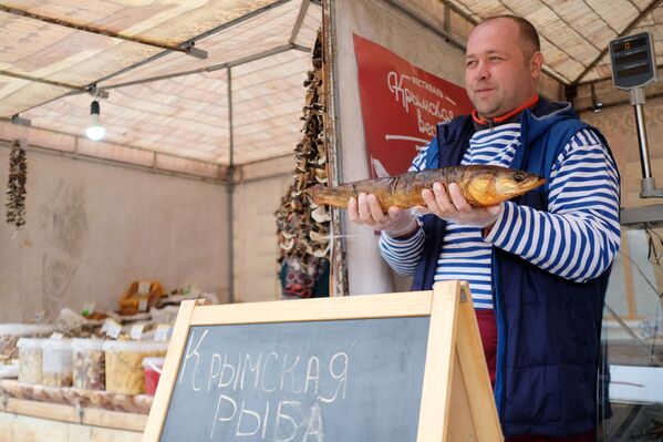 Продавец демонстрирует рыбу для продажи на ярмарке в рамках фестиваля Крымская весна в Краснодаре - Sputnik Абхазия