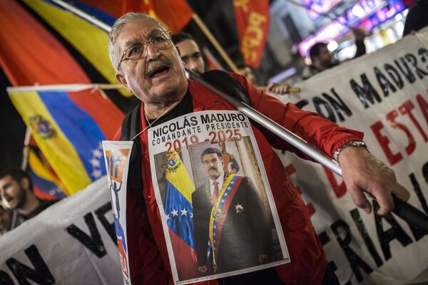 Участник акции в поддержку легитимного президента Венесуэлы Николаса Мадуро в Мадриде - Sputnik Абхазия