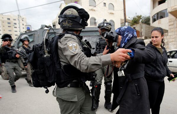 Женщина фотографирует израильского пограничника во время сноса палестинского дома, хозяева которого не оформили лицензии на строительство, в палестинском городе Бейт-Джала на территории Западного Берега Реки Иордан - Sputnik Абхазия