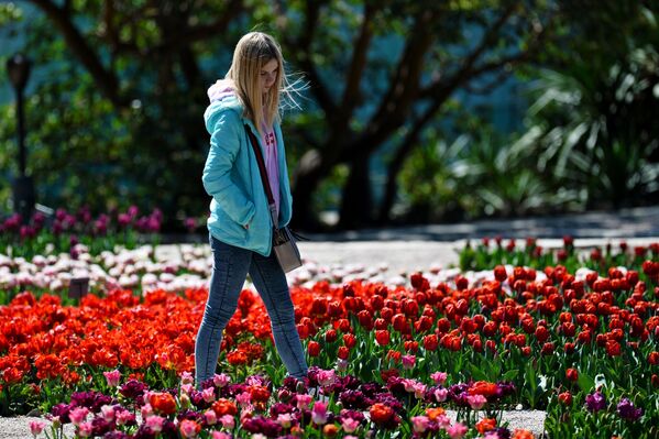 Девушка любуется цветами в Никитском ботаническом саду в Крыму - Sputnik Абхазия