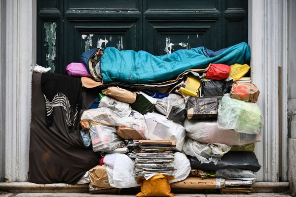 Бездомный спит на куче мусора под крыльцом в Риме, Италия - Sputnik Абхазия