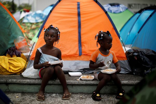 Девочки из Конго едят возле своей палатки в импровизированном лагере рядом с Национальным институтом миграции (INM) в Тапачуле, Мексика - Sputnik Абхазия