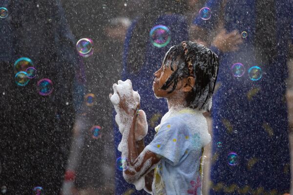 Девочка в окружении мыльных пузырей во время Бирманского новогоднего Водяного фестиваля в Янгоне, Мьянма - Sputnik Абхазия