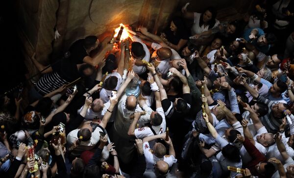 Верующие празднуют схождение Благодатного огня в храме Гроба Господня В Иерусалиме - Sputnik Абхазия
