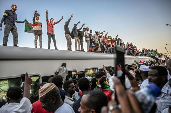 Суданские демонстранты из Атбара на крыше поезда, прибывшего в Хартум, в ходе противостояния между оппозицией и Военным советом - Sputnik Абхазия