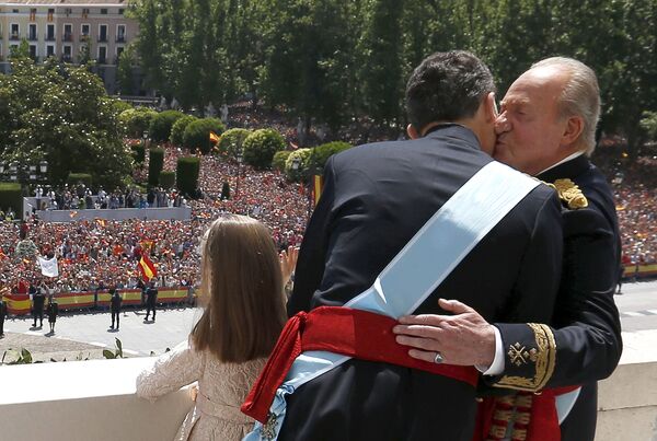 Испанский король Фелипе VI обнимается с бывшим королем Испании Хуаном Карлосом, в то время как принцесса София машет с балкона  - Sputnik Абхазия
