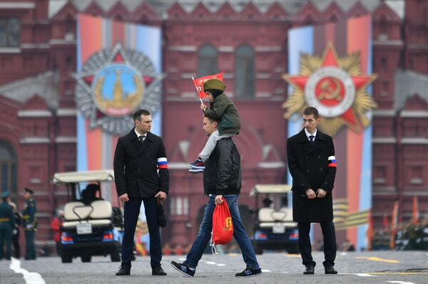 Мужчина с ребенком перед началом военного парада на Красной площади, посвящённого 74-й годовщине Победы в Великой Отечественной войне - Sputnik Абхазия