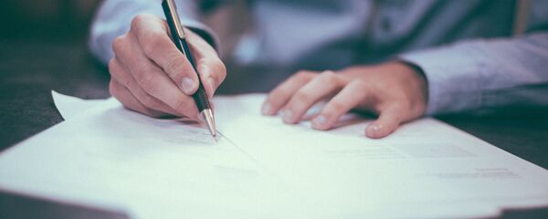 Человек подписывает документ Человек подписывает документ - Sputnik Абхазия