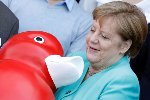 Канцлер Германии Ангела Меркель держит уточку, подаренную ей во время визита в компанию Centogene в городе Росток - Sputnik Абхазия
