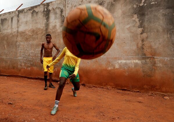  17-летняя Гаэль Дуле Ашери, входящая в первую группу девушек, которых тренируют профессиональные тренеры из Академии Rails Foot в Камеруне, играет в футбол с друзьями возле своего дома в Яунде - Sputnik Абхазия