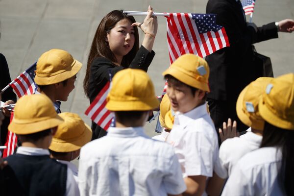 Японские школьники с американскими флагами готовятся к приезду президента США Дональда Трампа в Императорский дворец в Токио - Sputnik Абхазия