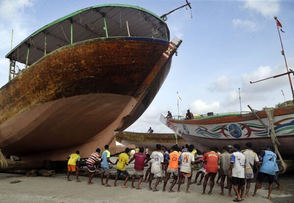 Индийские рыбаки вытаскивают на сушу корабль перед началом сезона муссонных дождей - Sputnik Абхазия